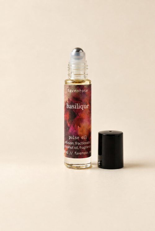 Basilique Pulse Oil with the black lid beside the bottle and stainless steel roller exposed