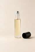 Vanilla Lace pulse oil with exposed stainless steel roller and black cap lying diagonally in the foreground